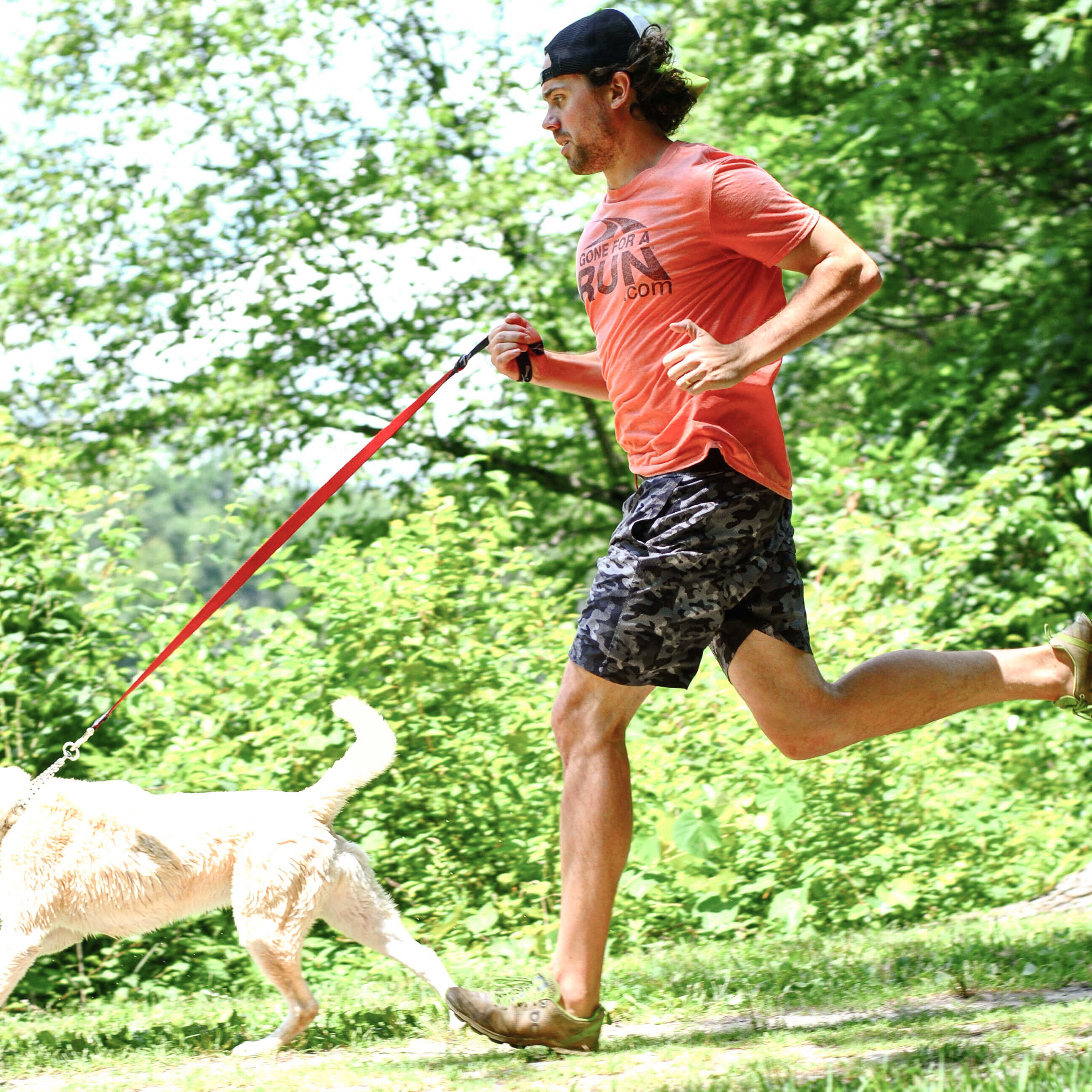 Guy running with his dog in the woods